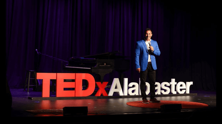Brandon Matthews speaking on the TEDxAlabaster stage, highlighting his insights on AI’s role in enhancing human connection.