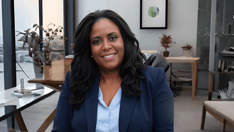 Dr. Twanna Carter in a professional blue suit, seated in a modern office environment.