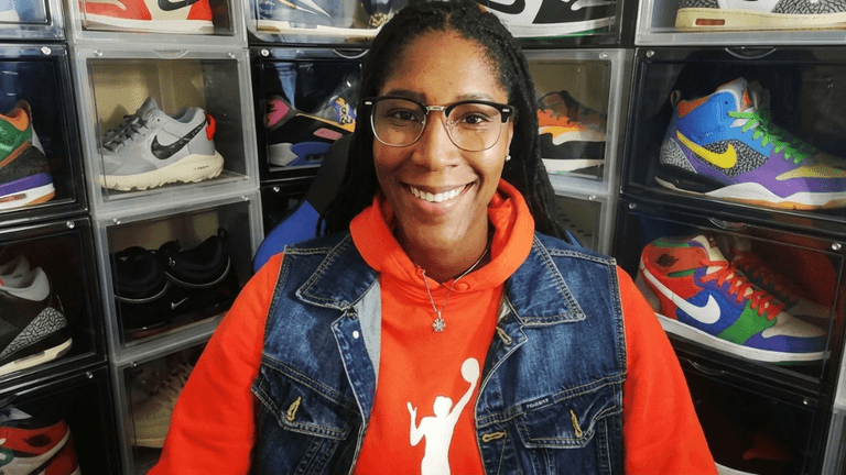 Michelle Snow smiling in front of a display of colorful athletic sneakers.