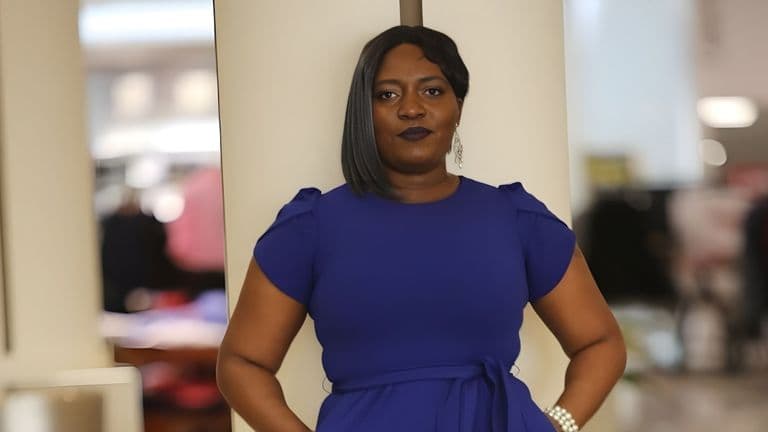 "Chantale C. Nyonka confidently posing in a blue dress, embodying empowerment, purpose, and authenticity through mindset coaching."