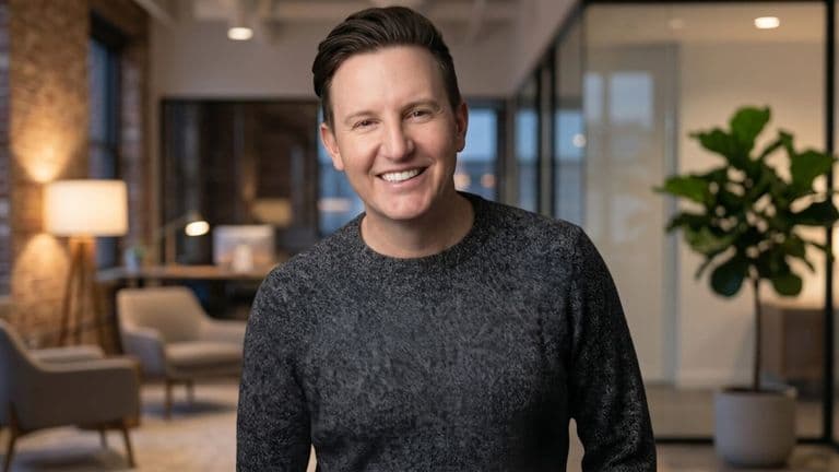 Smiling podcast host in modern office, promoting authentic LGBTQ+ conversations and community connection.