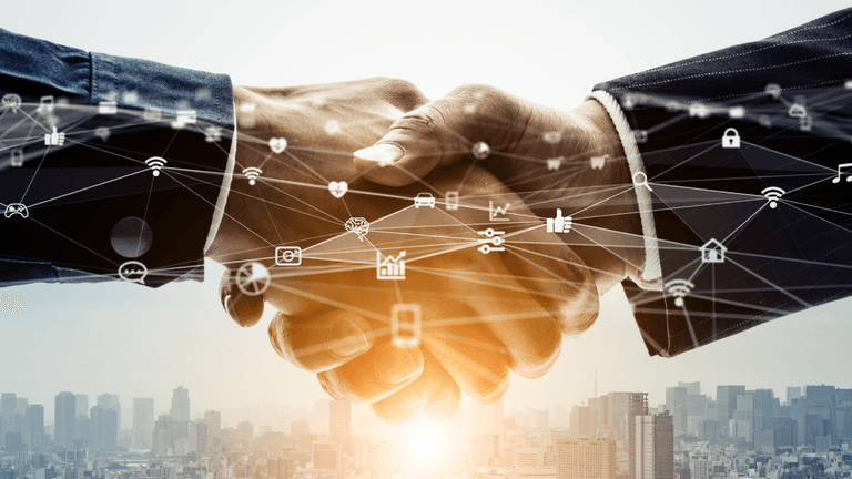 Business professionals shaking hands with digital technology icons over a city skyline.