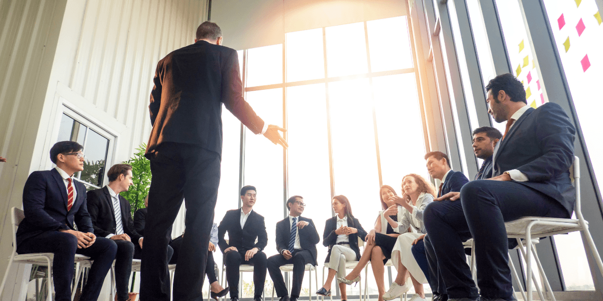 A group of business professionals engaged in discussion during a meeting in a modern space