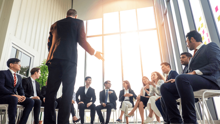 A group of business professionals engaged in discussion during a meeting in a modern space