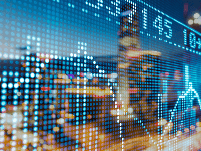 Digital stock market data overlaying a blurred cityscape at night
