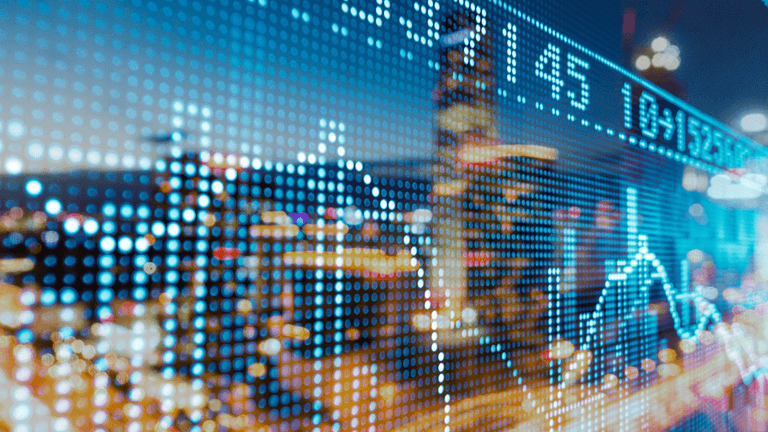 Digital stock market data overlaying a blurred cityscape at night