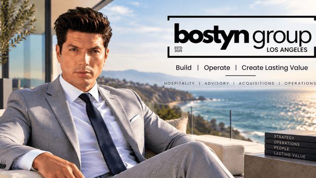 A man in a suit poses with a coastal view and text overlay for Bostyn Group.
