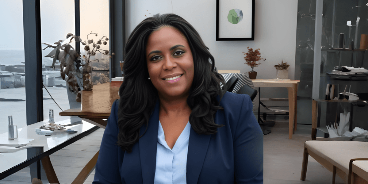 Dr. Twanna Carter in a professional blue suit, seated in a modern office environment.