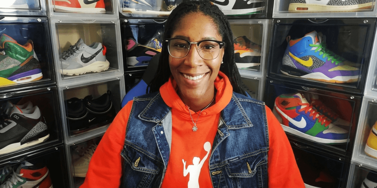 Michelle Snow smiling in front of a display of colorful athletic sneakers.