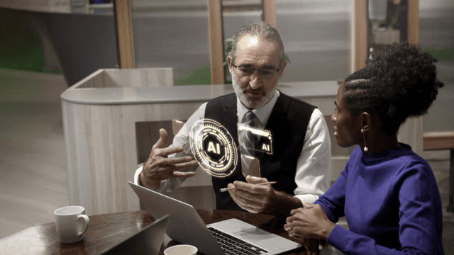 Two professionals discussing AI strategy at a table with a laptop and digital AI interface graphic.