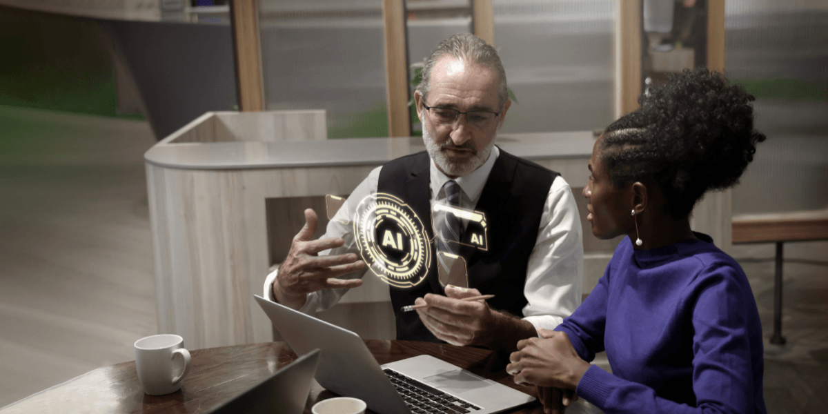 Two professionals discussing AI strategy at a table with a laptop and digital AI interface graphic.