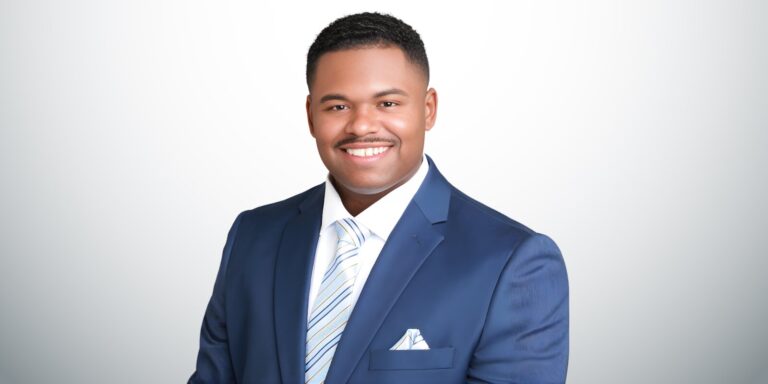 Daniel McDavid, a black man in a blue suit and tie, symbolizes the mission of Move Mountains Credit Repair.