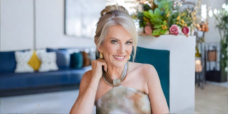 A woman sits in a chair beside a blue couch, reflecting on her journey of self-discovery and empowerment.