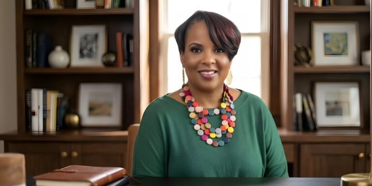 A woman wearing a green shirt is seated at a desk, symbolizing the initiative of IMPACT Ready for small business success.